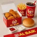 A meal from Al Baik featuring crispy fried chicken, French fries, a soft burger bun, sauces, and a soft drink.