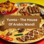A vibrant platter from Yumto menu – The House of Arabic Mandi in South Islamabad Eats, featuring a generous spread of aromatic mandi rice topped with grilled chicken, kebabs, and fish fillets, garnished with sliced tomatoes, onions, and lemon for a colorful Arabian feast.